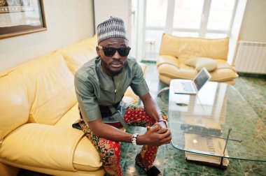 Onun daire, kanepede oturan zengin Afrika adam. Portresi 