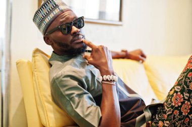 Onun daire, kanepede oturan zengin Afrika adam. Portresi 