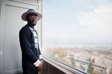 Zengin Afrika adam onun çatı katı panoramik pencereden bakıyor. P