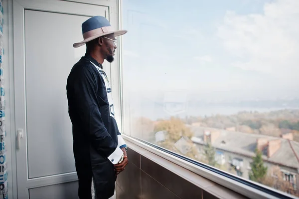 Rika afrikanska mannen tittar på panoramafönster på hans penthouse. P — Stockfoto