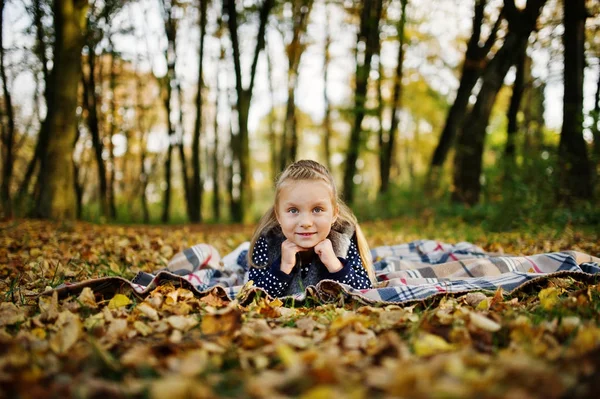 Niña sentada a cuadros en el majestuoso bosque otoñal . —  Fotos de Stock