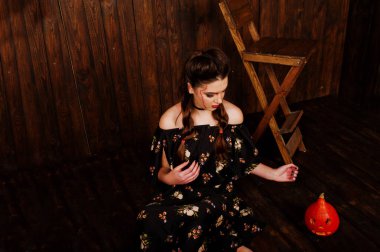 Parlak makyaj ve kabak ahşap karşı elbiseli siyah kız