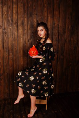 Parlak makyaj ve kabak ahşap karşı elbiseli siyah kız