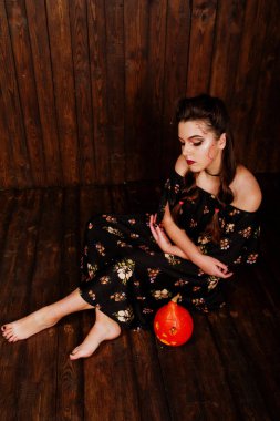 Parlak makyaj ve kabak ahşap karşı elbiseli siyah kız