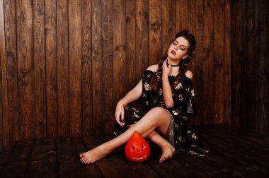 Parlak makyaj ve kabak ahşap karşı elbiseli siyah kız