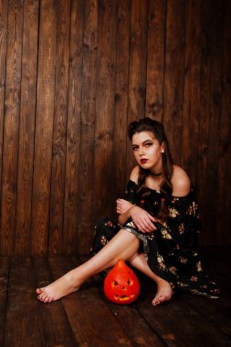 Parlak makyaj ve kabak ahşap karşı elbiseli siyah kız