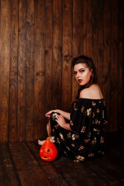 Parlak makyaj ve kabak ahşap karşı elbiseli siyah kız