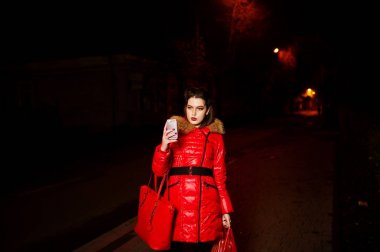 Kız telefon vuruşta geceleri yapıyor kırmızı ceketli.