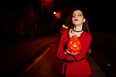 Kırmızı gömlek ve parlak makyaj ile kabak elinde siyah kız