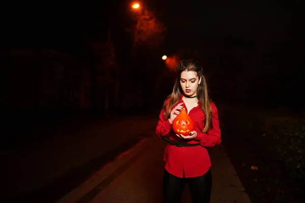 Zwart meisje in de rode shirt en lichte make-up met pompoen op handen — Stockfoto