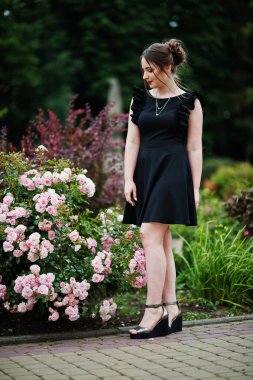 Üzerinde yürüyen siyah elbiseli güzel bir genç kız portresi 