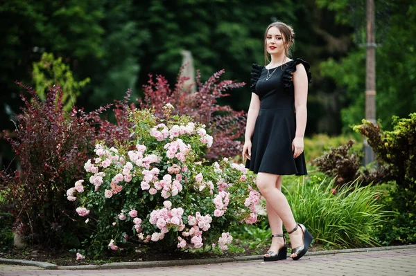 Portrait d'une magnifique jeune fille en robe noire marchant sur le — Photo