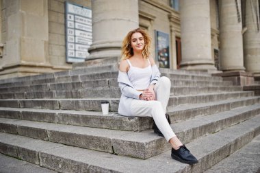 Beyaz fincan kahve ile şık kıvırcık sarışın model kız aşınma