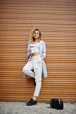 Beyaz fincan kahve ile şık kıvırcık sarışın model kız aşınma