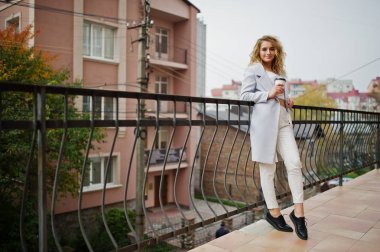 Beyaz fincan kahve ile şık kıvırcık sarışın model kız aşınma