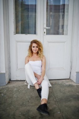 Şık kıvırcık sarışın model kız giymek beyaz eski karşı poz üzerinde