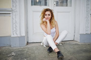 Şık kıvırcık sarışın model kız giymek beyaz eski karşı poz üzerinde