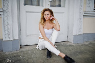 Şık kıvırcık sarışın model kız giymek beyaz eski karşı poz üzerinde