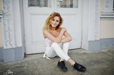 Şık kıvırcık sarışın model kız giymek beyaz eski karşı poz üzerinde