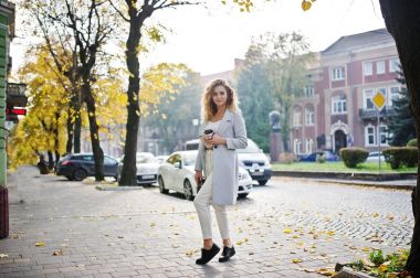 Beyaz fincan kahve ile şık kıvırcık sarışın model kız aşınma