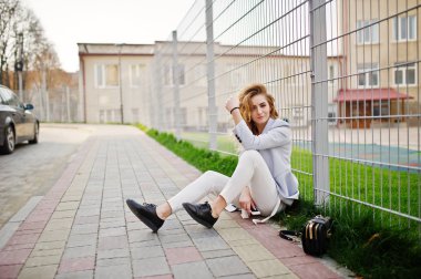 Şık kıvırcık sarışın model kız giymek beyaz fen karşı poz üzerinde