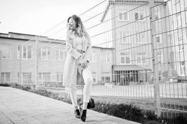 Şık kıvırcık sarışın model kız giymek beyaz fen karşı poz üzerinde