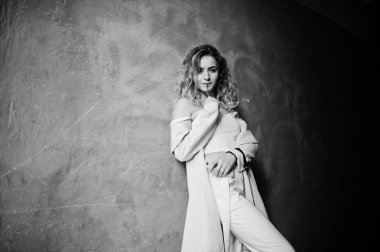 Şık kıvırcık sarışın model kız giymek beyaz ora karşı poz üzerinde