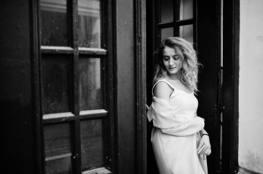 Şık kıvırcık sarışın model kız giymek beyaz eski karşı poz üzerinde