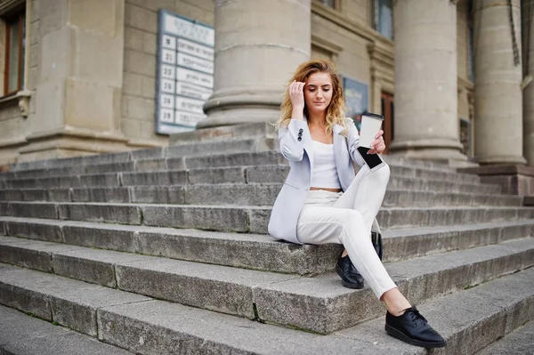 Élégant bouclé blonde modèle fille porter sur blanc avec tasse de café — Photo