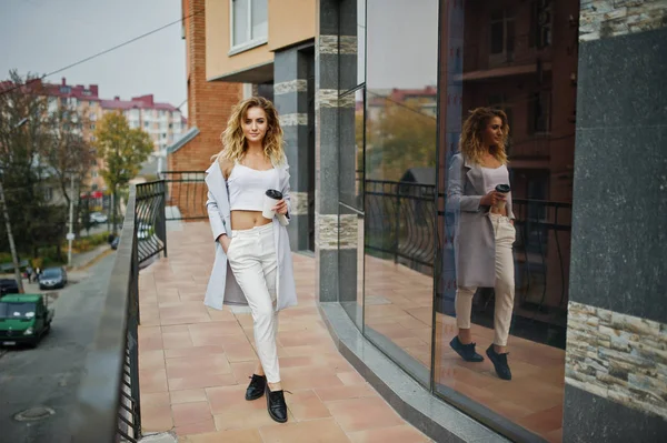 Elegante encaracolado loira modelo menina desgaste no branco com xícara de café — Fotografia de Stock