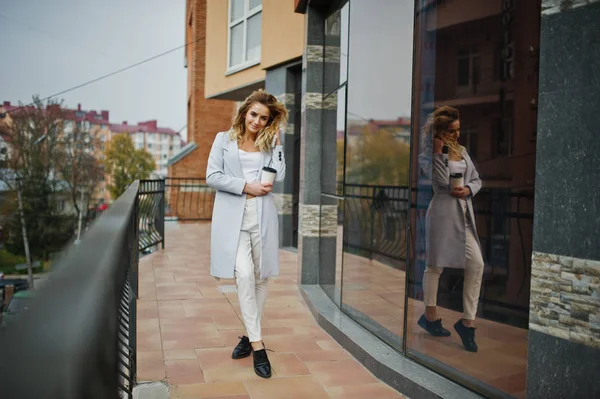 Elegante encaracolado loira modelo menina desgaste no branco com xícara de café — Fotografia de Stock