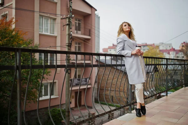 Elegante encaracolado loira modelo menina desgaste no branco com xícara de café — Fotografia de Stock