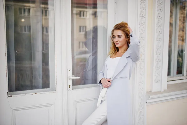 Elegante modelo rubio rizado chica usar en blanco posando contra el viejo —  Fotos de Stock