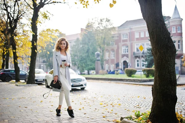 Eleganta Lockigt blond modell flicka bära på vitt med kopp kaffe — Stockfoto