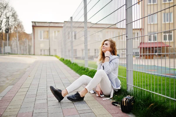 Şık kıvırcık sarışın model kız giymek beyaz fen karşı poz üzerinde