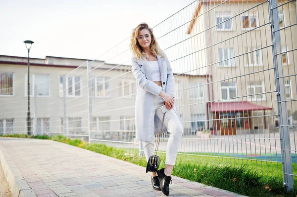 Stylish curly blonde model girl wear on white posing against fen — Stock Photo, Image