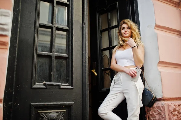 Elegante encaracolado loira modelo menina desgaste no branco posando contra o velho — Fotografia de Stock