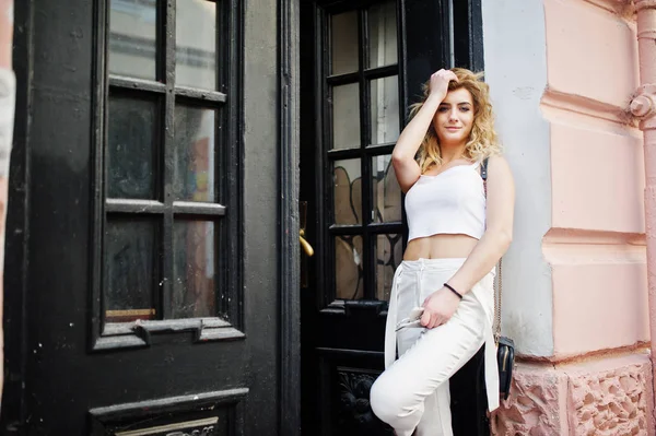 Şık kıvırcık sarışın model kız giymek beyaz eski karşı poz üzerinde
