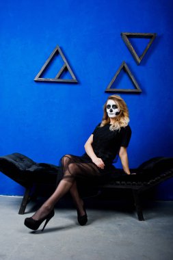 Cadılar Bayramı kafatası makyaj kız giyim siyah mavi duvara karşı 