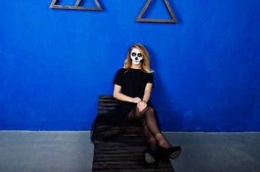 Cadılar Bayramı kafatası makyaj kız giyim siyah mavi duvara karşı 