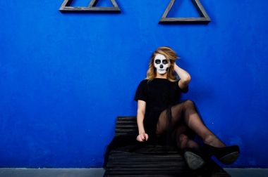 Cadılar Bayramı kafatası makyaj kız giyim siyah mavi duvara karşı 