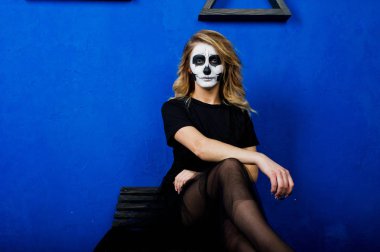 Cadılar Bayramı kafatası makyaj kız giyim siyah mavi duvara karşı 