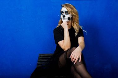 Cadılar Bayramı kafatası makyaj kız giyim siyah mavi duvara karşı 