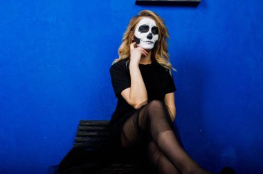 Cadılar Bayramı kafatası makyaj kız giyim siyah mavi duvara karşı 