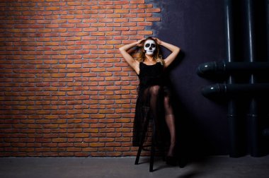 Cadılar Bayramı kafatası kara karşı tuğla duvara kız giyim makyaj