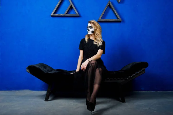 Halloween schedel meisje slijtage in het zwart tegen blauwe muur op make-up — Stockfoto