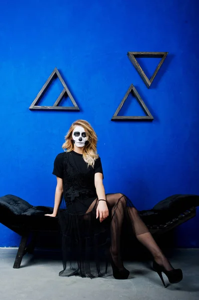 Halloween cranio make up ragazza indossare in nero contro muro blu a — Foto Stock