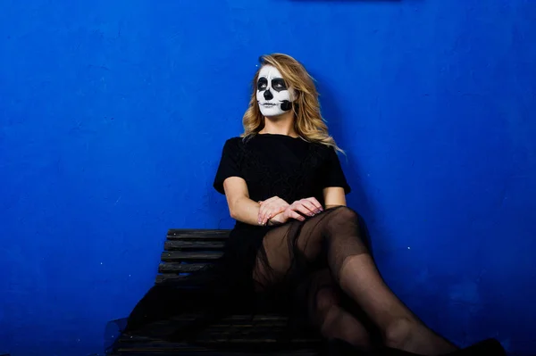Cadılar Bayramı kafatası makyaj kız giyim siyah mavi duvara karşı — Stok fotoğraf