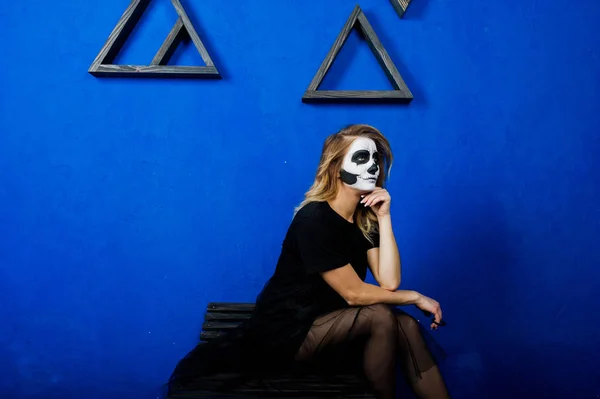 Halloween cranio make up ragazza indossare in nero contro muro blu a — Foto Stock