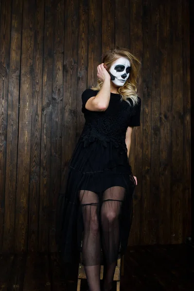 Crâne d'Halloween maquillage fille porter en noir contre le mur en bois a — Photo